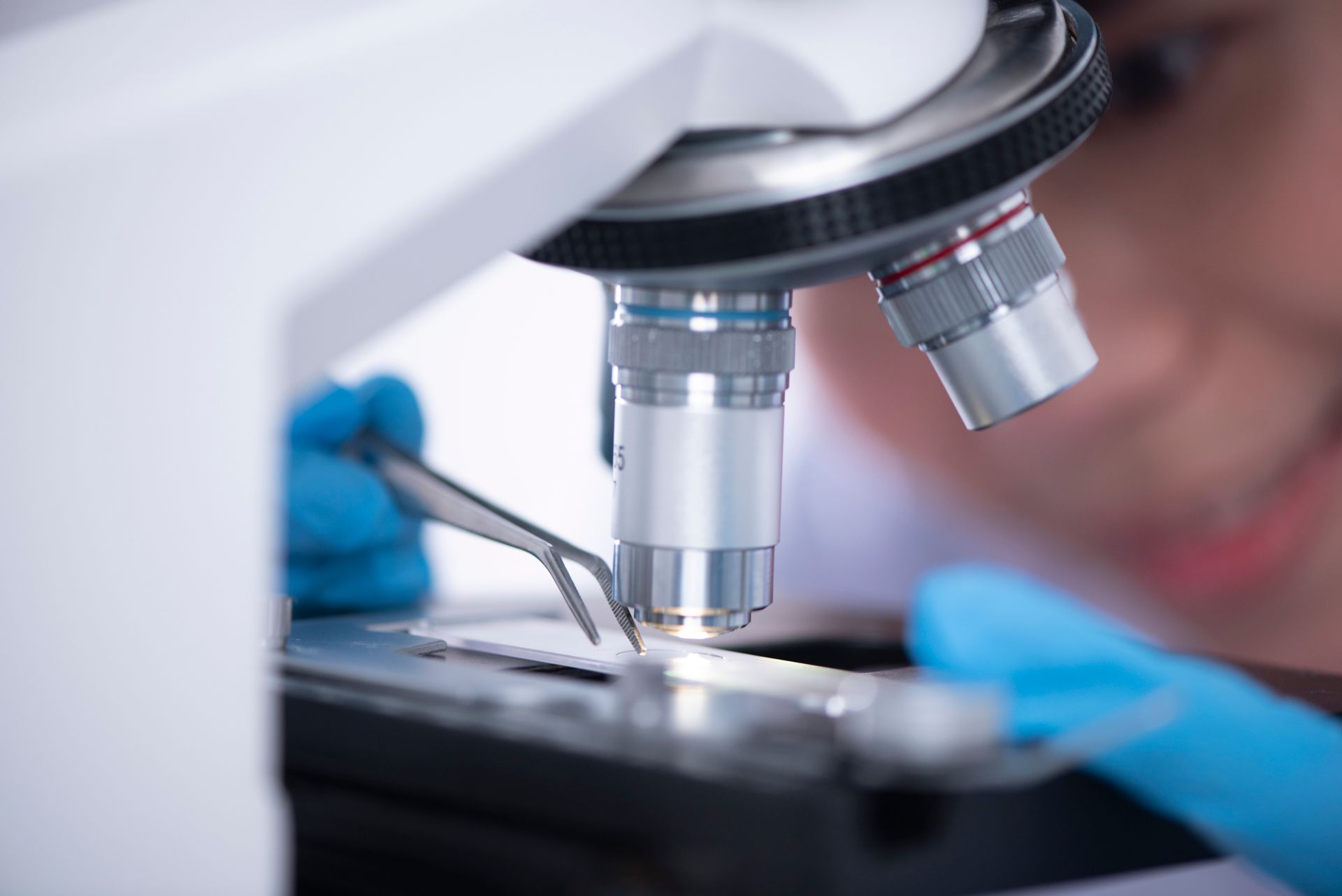 A scientist examining a sample through a microscope